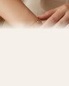 Gold charm bracelet on wrist